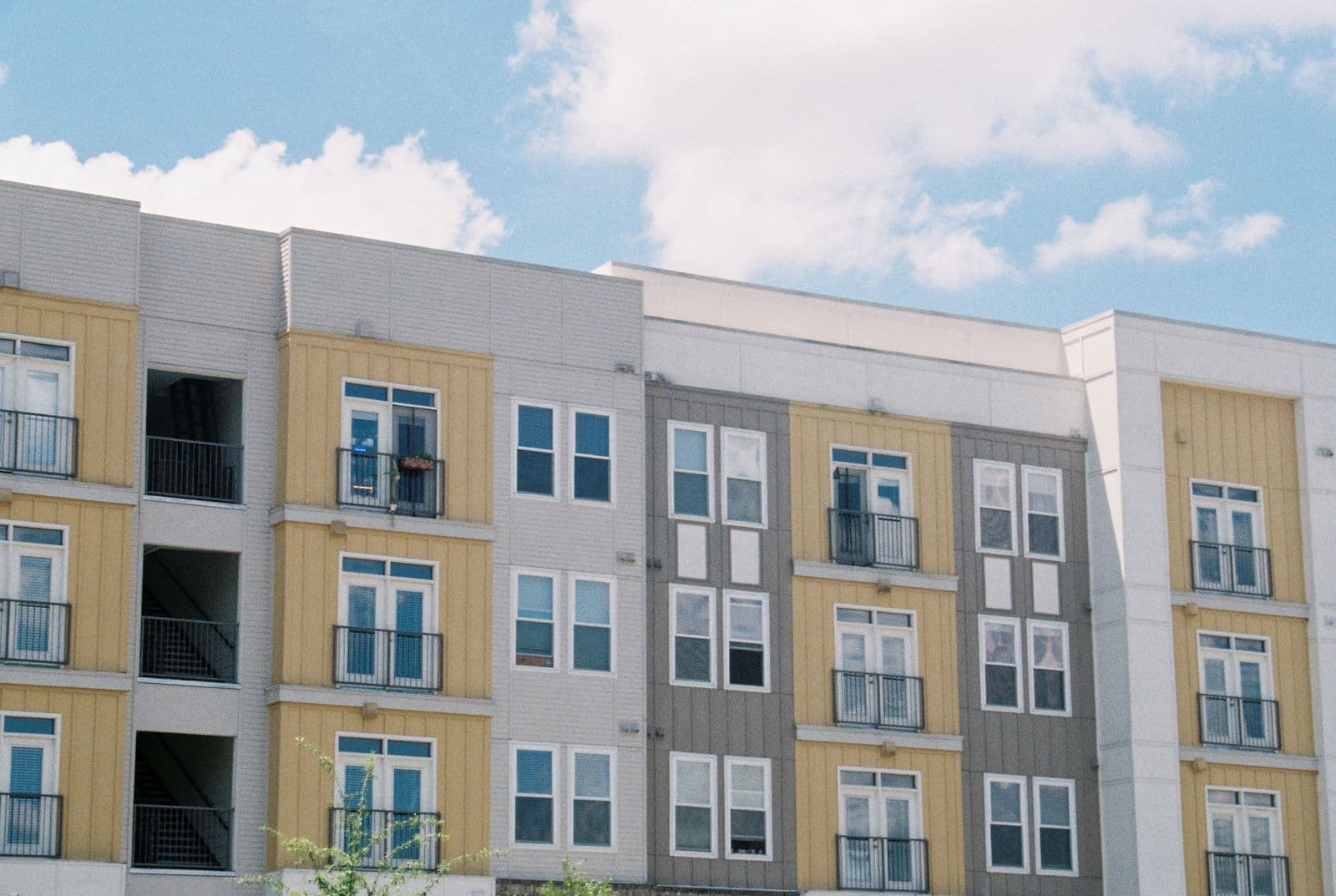 Multi-storey apartment building with balconies and yellow and grey panels