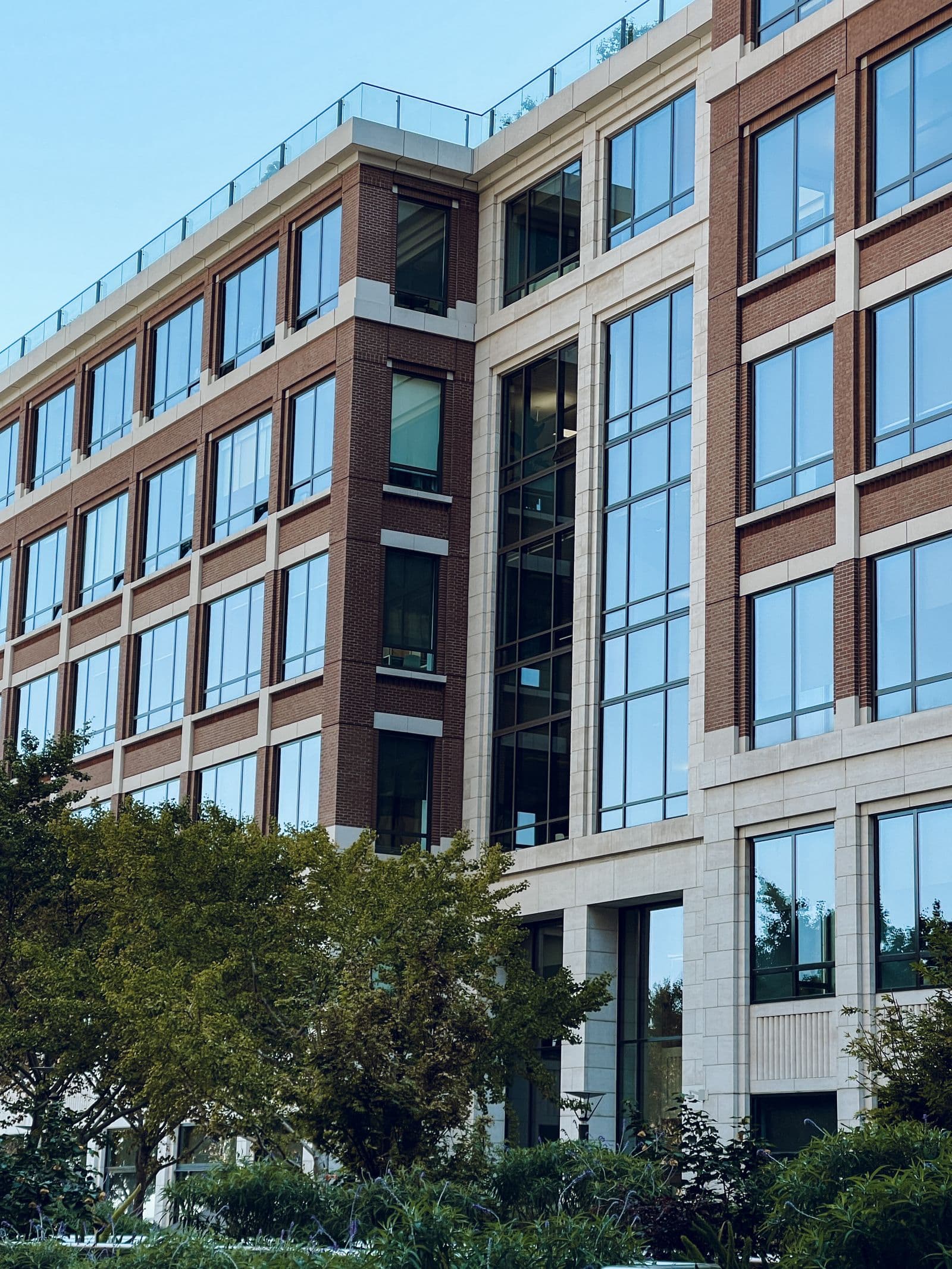 Modern low-rise office building with glass windows and tan panelling