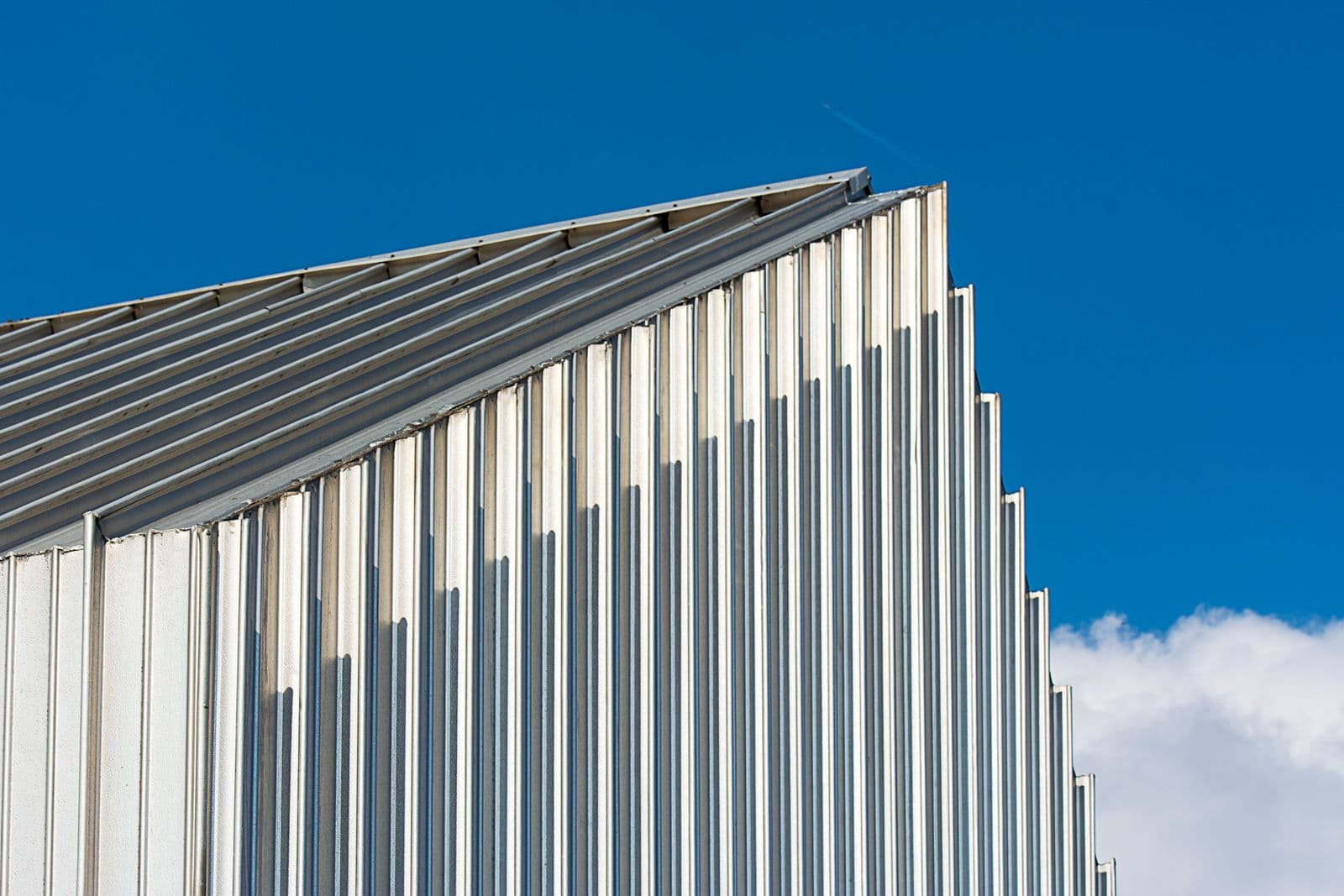 Ribbed standing-seam metal roof panels against a clear blue sky
