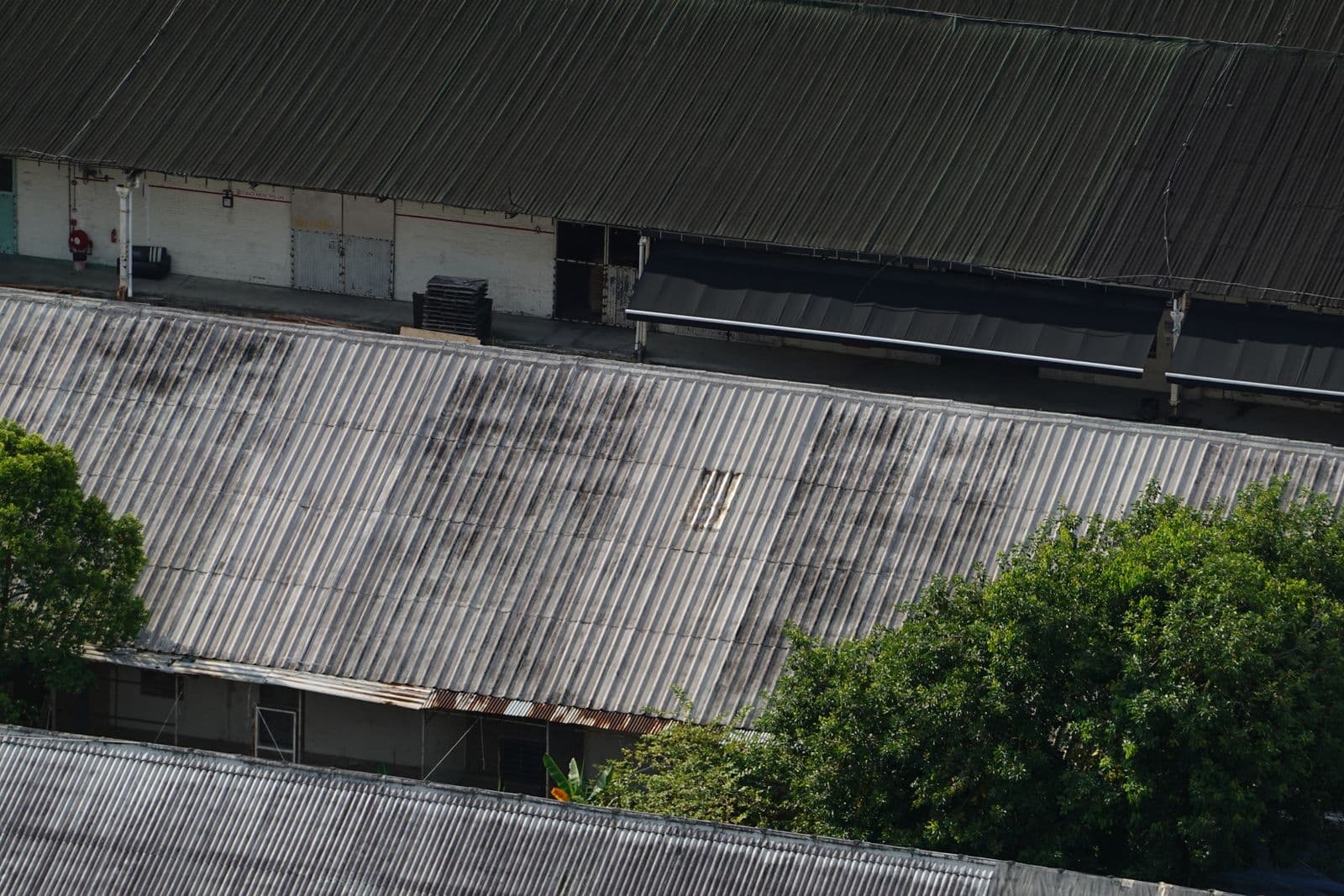 Weathered metal commercial roof showing storm wear across its panels