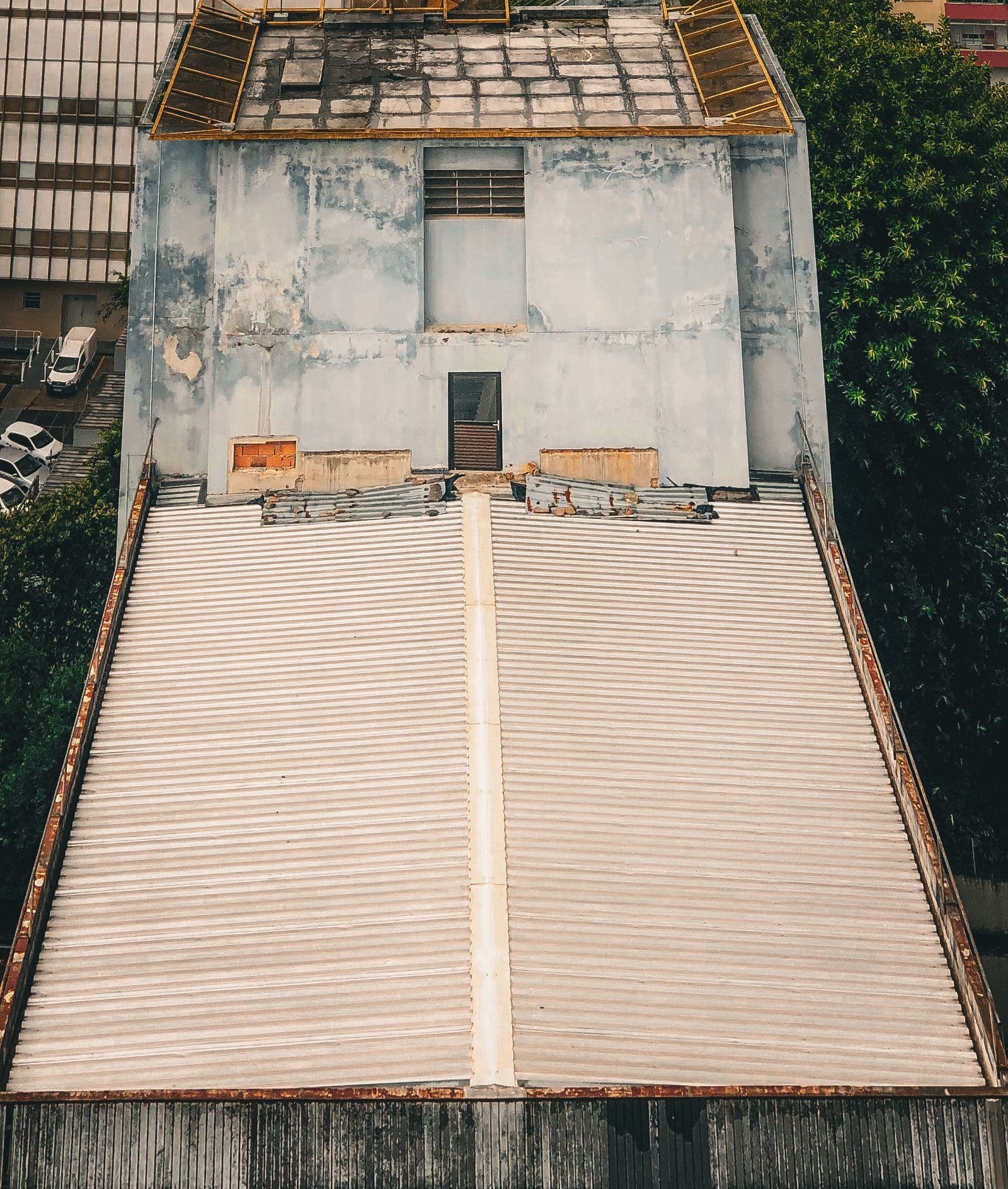 Overhead view of a pale single-ply membrane flat roof between parapet walls