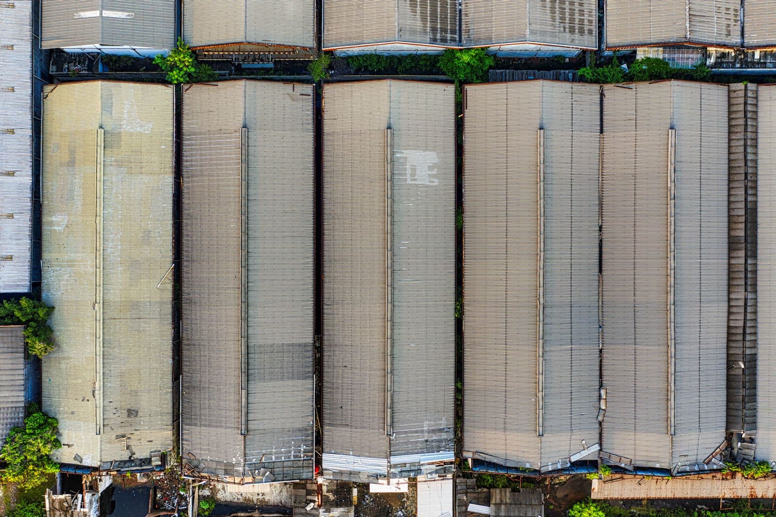 Aerial view of a row of warehouse units with long pale roofs