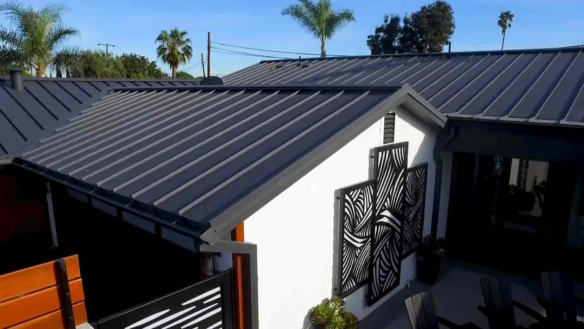 Charcoal standing-seam metal roof on a white stucco home