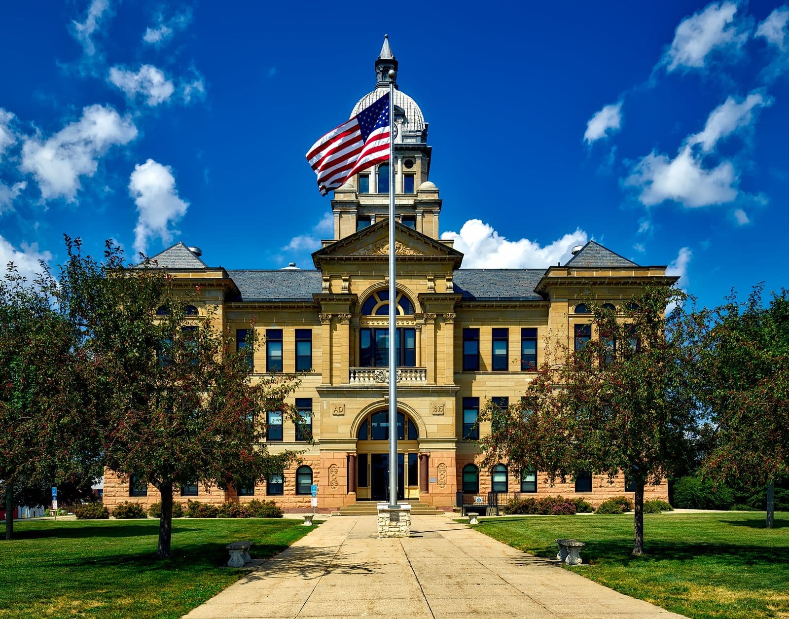 American county courthouse with a US flag flying from its tower against a blue sky