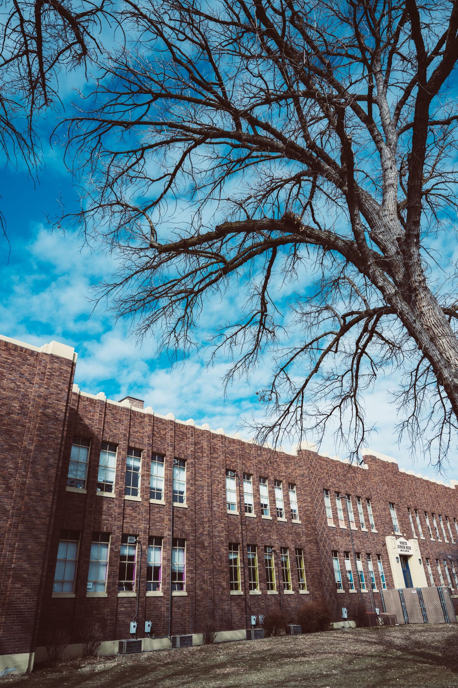 Completed brick school building under a clear sky after a roof replacement