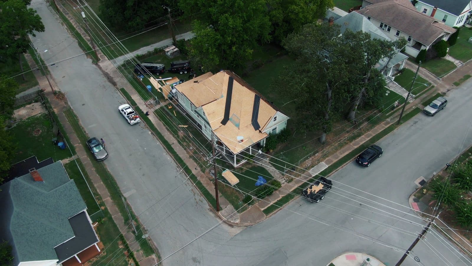 Aerial view of a house with its roof stripped to the decking, as measured for a quote
